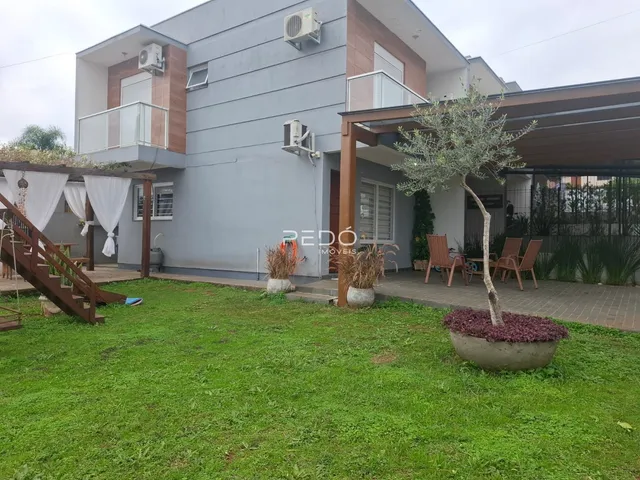 Fachada de uma casa em Lajeado, Brasil com jardim e área externa.