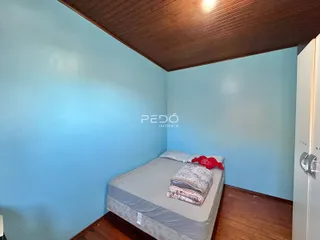 Foto de um quarto com cama e paredes azuis em uma residência.