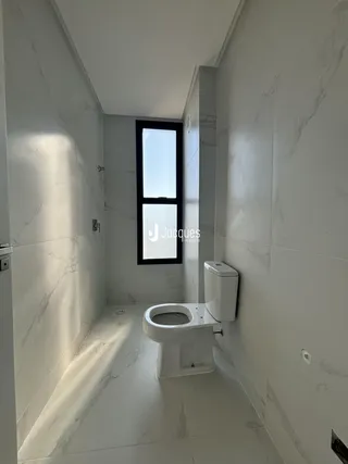 Vista de um banheiro moderno com revestimento em mármore branco.