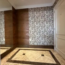 Foto do piso e da parede decorada de uma área interna.
