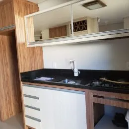 Foto de uma cozinha com armários brancos e bancadas escuras.