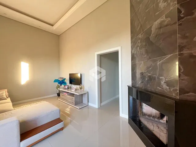 Sala de estar com piso claro e parede de destaque em um imóvel no Brasil.