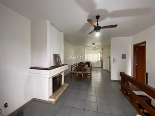 Sala de estar com lareira e área de jantar em um imóvel no Brasil.