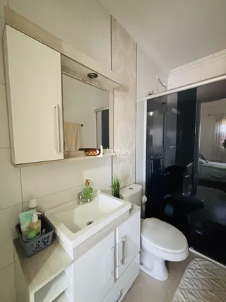 Foto de um banheiro moderno com bancada branca e box de vidro.