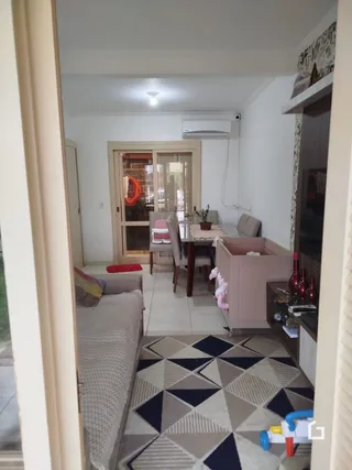 Vista interna de uma sala de estar com piso de cerâmica e porta de entrada.