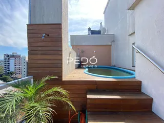 Vista de uma área externa com deck de madeira e piscina em Lajeado.