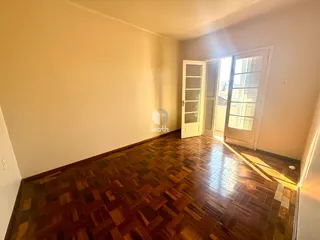 Vista de um corredor com piso de madeira em uma residência.