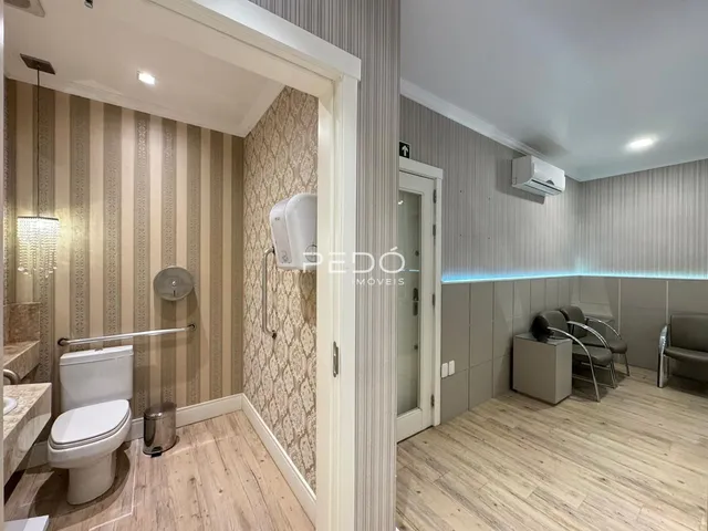 Foto de um banheiro com piso de madeira clara e paredes texturizadas.