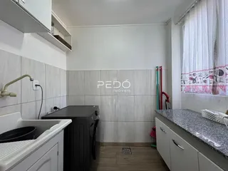 Banheiro com revestimento cerâmico e piso de madeira.