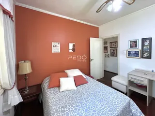 Quarto com cama e parede em tom terracota.