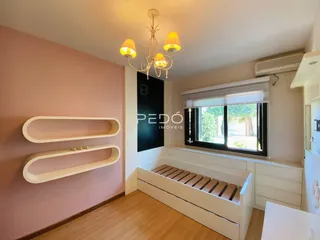 Ambiente interno de uma sala com paredes rosa e piso de madeira clara.