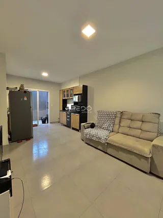 Sala de estar com cozinha e área de passagem em um imóvel no Brasil.