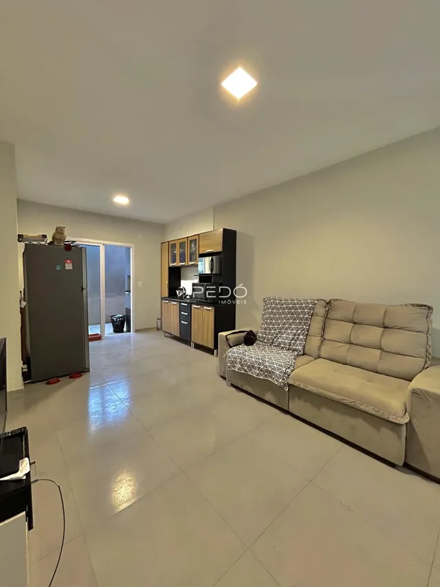 Sala de estar com cozinha e área de passagem em um imóvel no Brasil.
