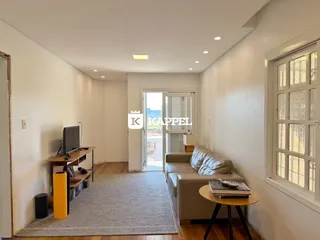 Esta é uma sala de estar com sofá e televisão em um ambiente claro.