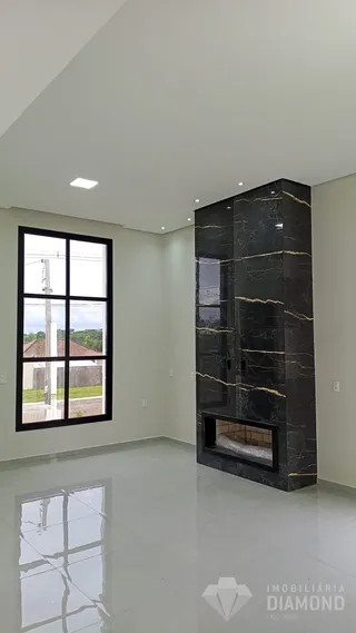 Interior de uma sala com grande janela e parede de destaque escura.
