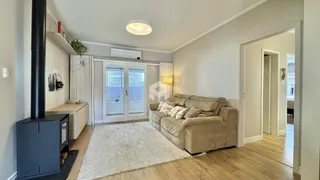 Sala de estar com sofá e piso de madeira clara.