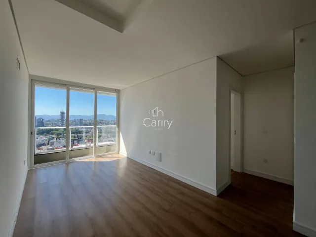 Sala de estar com grandes janelas que proporcionam uma vista panorâmica da paisagem urbana.