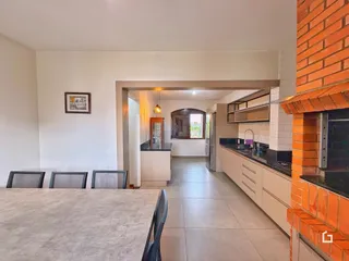 Interior de uma sala de estar com cozinha em um imóvel em Lajeado, Brasil.