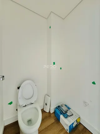 Foto de um banheiro interno com vaso sanitário e piso de madeira.