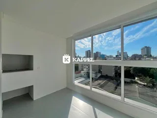 Sala de estar com grandes janelas que oferecem uma vista da cidade.