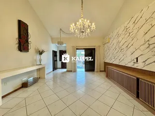 Sala ampla com piso de cerâmica e parede de destaque em mármore.