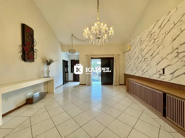 Sala ampla com piso de cerâmica e parede de destaque em mármore.