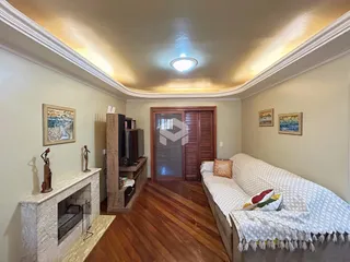 Sala de estar com piso de madeira e lareira em um imóvel no Brasil.