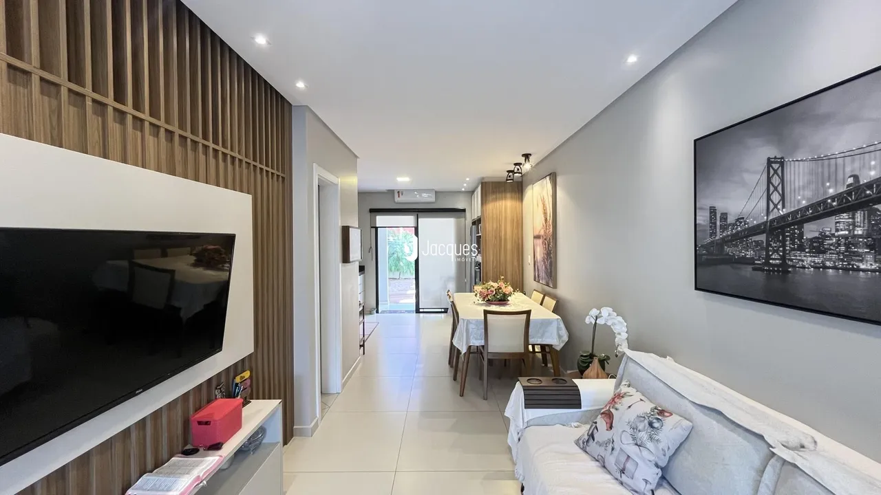 Sala de estar moderna com painéis de madeira e televisão.