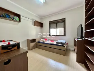 Quarto com cama e estante de madeira em um imóvel no Brasil.