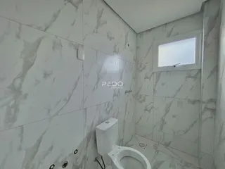 Foto de um banheiro com revestimento de mármore branco.