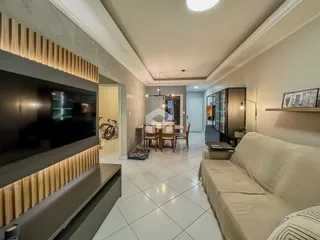 Sala de estar com televisão e área de passagem em um apartamento.