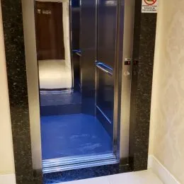 Vista interna de um box de banheiro com revestimento azul e vidro.