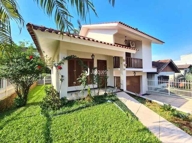 Fachada de uma casa em Lajeado, Brasil, com jardim verde e vegetação.