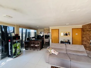 Sala de estar com sofá e área de jantar em um imóvel no Brasil.