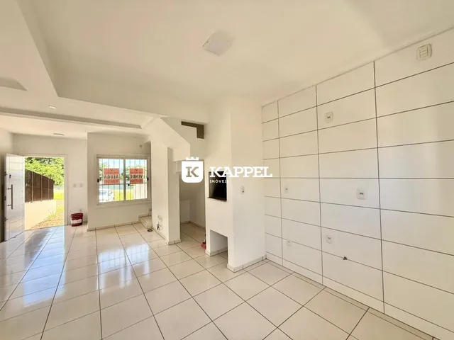 Ambiente interno amplo com piso de porcelanato claro e paredes brancas.