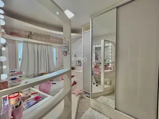 Quarto com decoração clara e espelho no ambiente.