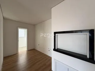 Interior de um ambiente com piso de madeira e paredes brancas.