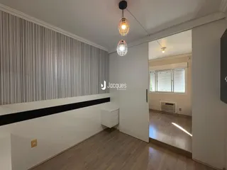 Sala de estar com piso de madeira e parede texturizada.