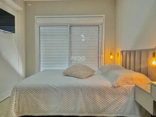 Quarto com cama e porta de vidro no interior da residência.