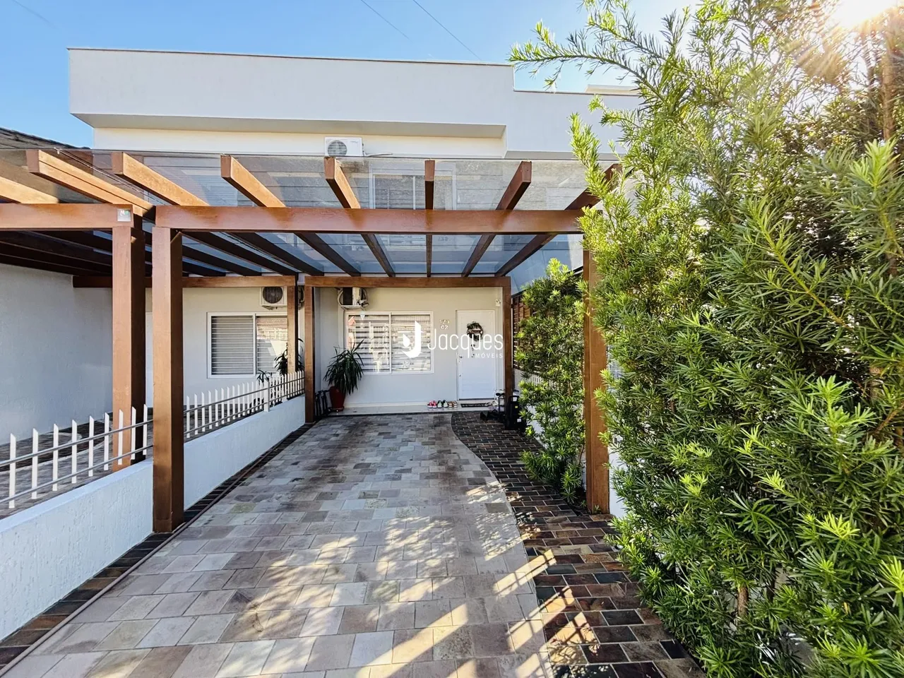 Fachada de uma casa em Lajeado, Brasil com uma área coberta e jardim lateral.