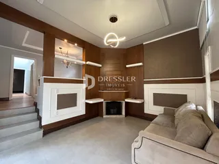 Sala de estar com parede de madeira e lareira em um imóvel no Brasil.