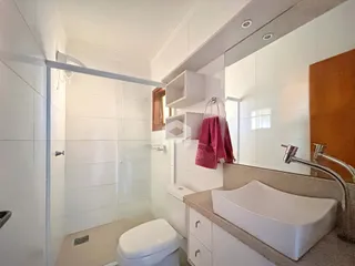 Foto de um banheiro interno com revestimento cerâmico e box de vidro.