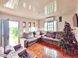 Sala de estar com sofás cinzas e piso de ladrilho, com vista para o exterior.