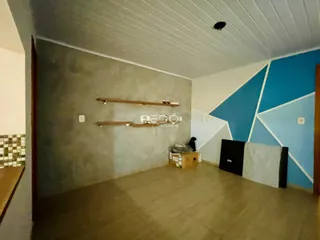 Interior de uma sala com paredes em tons de cinza e azul e piso claro.