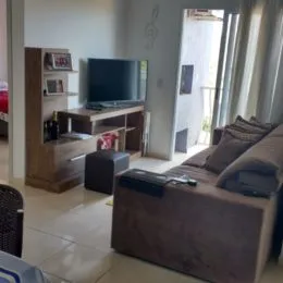 Sala de estar com sofá e televisão em um ambiente interno.