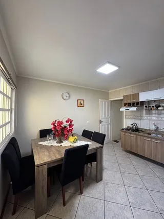 Foto de uma sala de jantar com mesa e cadeiras em um ambiente interno.