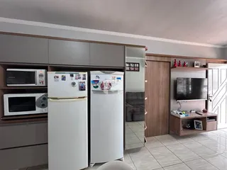 Foto de uma cozinha com armários e eletrodomésticos brancos.