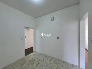 Hall de entrada com piso de cerâmica claro e paredes brancas.