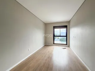 Vista de um corredor interno com piso de madeira clara.