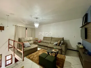 Sala de estar com sofá e escadaria em um imóvel no Brasil.